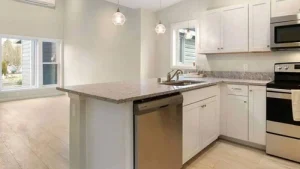 A kitchen with stainless steel appliances and white cabinets.