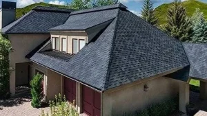 An aerial view of a large house with a black roof.