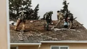 A group of men are working on the roof of a house.